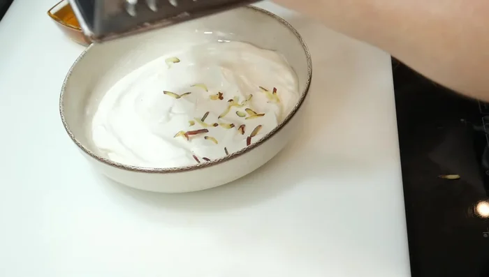Esparcir la fruta rallada sobre la capa de yogur.